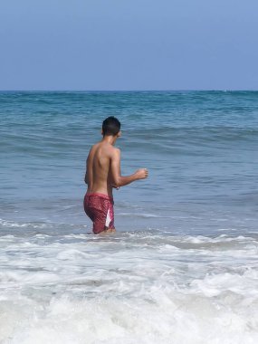 Faslı çocuk ona doğru gelen dalgaları izliyor.