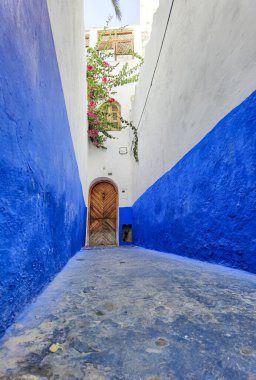 Asilah 'ın Medine' sinde mavi beyaz geçitli kahverengi ahşap kapı.