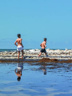 Fas sahilinde birlikte oynayan iki genç çocuk.