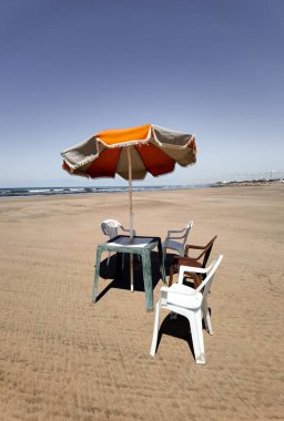 Fas sahilinde sandalyeli ve şemsiyeli bir masa.