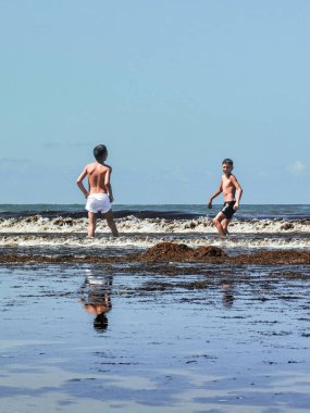 Fas sahilinde birlikte oynayan iki genç çocuk.