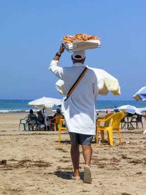 Fas sahilinde tatlı çörek satan bir adam.