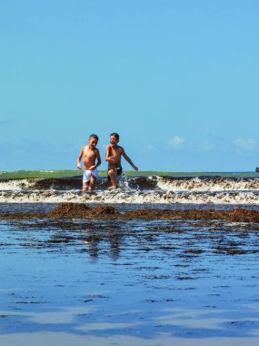 Fas sahilinde birlikte oynayan iki genç çocuk.