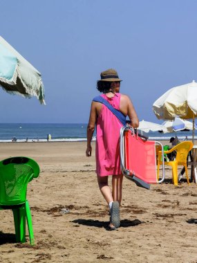 Sahilde yürüyen Faslı kadın.