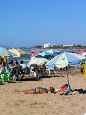 Faslı kadın sahilde güneşleniyor.