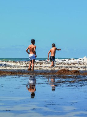 Fas sahilinde birlikte oynayan iki genç çocuk.