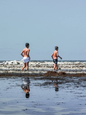 Fas sahilinde birlikte oynayan iki genç çocuk.
