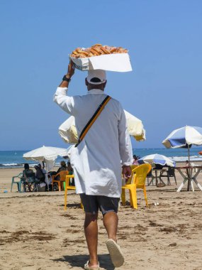 Fas sahilinde tatlı çörek satan bir adam.