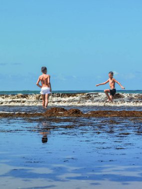 Fas sahilinde birlikte oynayan iki genç çocuk.