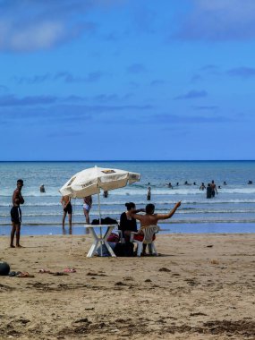 Faslı insanlar sahilde eğleniyor.
