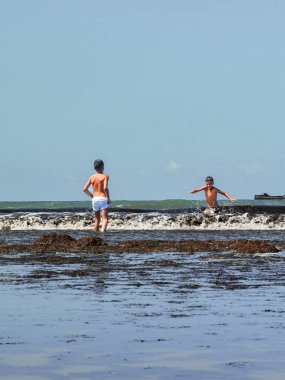Fas sahilinde birlikte oynayan iki genç çocuk.