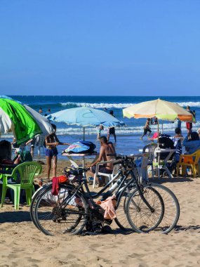 Birkaç bisiklet kalabalık bir plaj ve birkaç şemsiye.