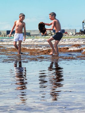 Fas sahilinde birlikte oynayan iki genç çocuk.