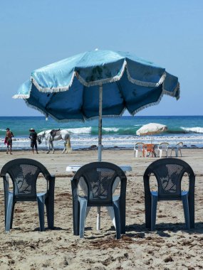 Fas sahilinde sandalyeli ve şemsiyeli bir masa.