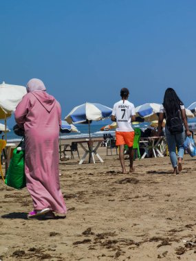 Sahilde yürüyen Faslı kadın.