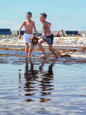 Fas sahilinde birlikte oynayan iki genç çocuk.