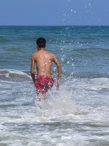 Faslı bir adam okyanusun ortasına doğru yürüyor.