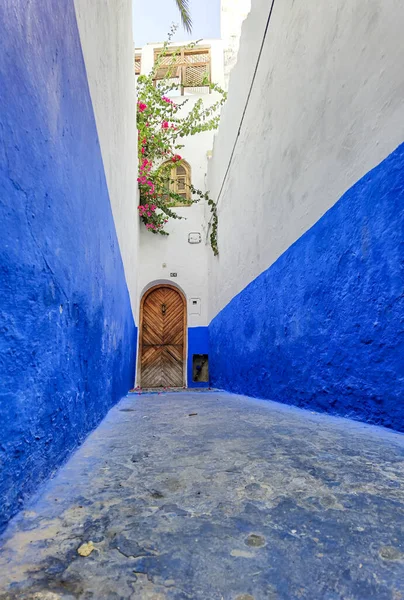 Asilah 'ın Medine' sinde mavi beyaz geçitli kahverengi ahşap kapı.