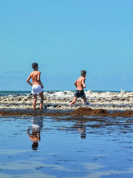 Fas sahilinde birlikte oynayan iki genç çocuk.