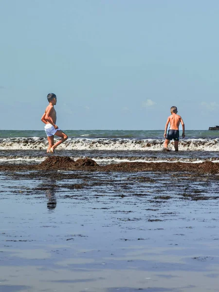 Fas sahilinde birlikte oynayan iki genç çocuk.