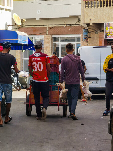 Moroccan man pushing full cart in the road