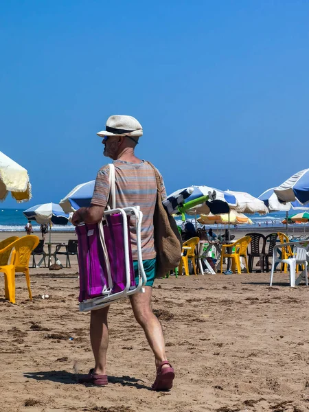 Faslı bir adam sahilde yürüyor.