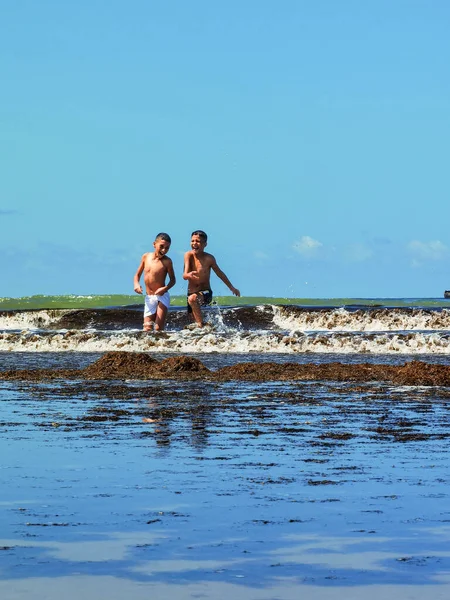 Fas sahilinde birlikte oynayan iki genç çocuk.