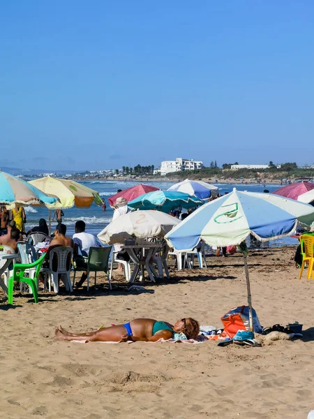 Faslı kadın sahilde güneşleniyor.