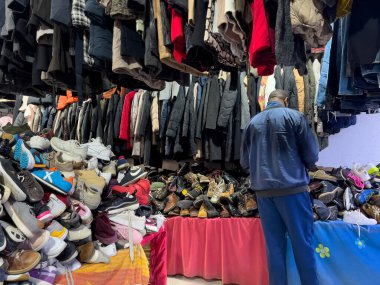 Fas 'ta ikinci el dükkanında ayakkabı seçen bir adam.