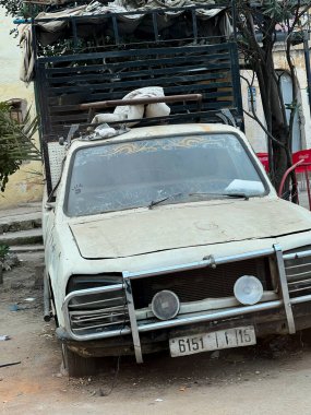 Yol kenarında terk edilmiş eski paslı bir araba.