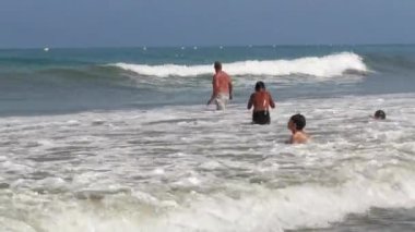 Birçok çocuk sahilde birlikte yüzüyor.