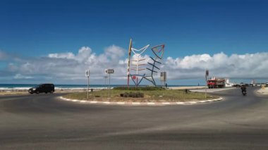 Assilah 'ta metalik bir balık heykeli etrafında dönen arabalar