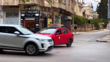 Fas 'ta kırmızı bir taksiye çarpmadan önce motosiklet fren yapıyor.