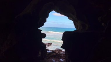 Karanlık bir mağaranın içinden deniz manzarası