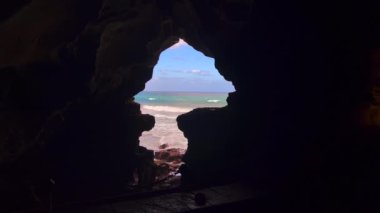 Karanlık bir mağaranın içinden deniz manzarası