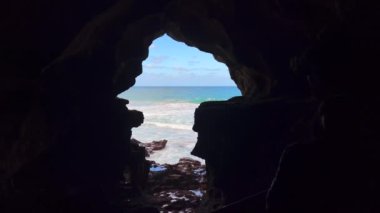 Karanlık bir mağaranın içinden deniz manzarası