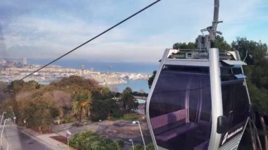 Barselona üzerinde hareket eden bir teleferiğin hava görüntüsü.