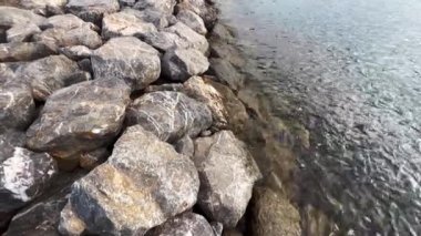 Sahildeki kayalara vuran kısa deniz dalgalarının sakin manzarası.