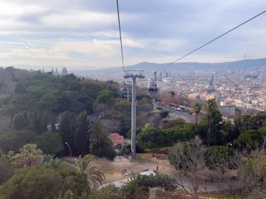 Barselona üzerinde hareket eden bir teleferiğin hava görüntüsü.