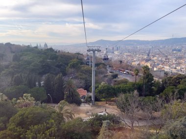 Barselona üzerinde hareket eden bir teleferiğin hava görüntüsü.