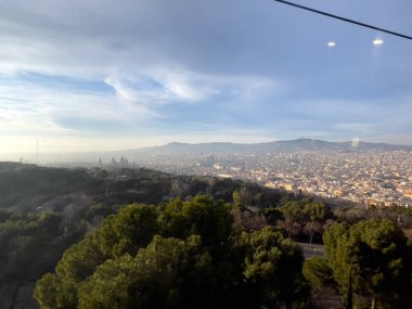 Barselona üzerinde hareket eden bir teleferiğin hava görüntüsü.