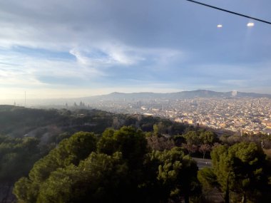 Barselona üzerinde hareket eden bir teleferiğin hava görüntüsü.