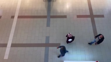 Bir alışveriş merkezinin koridorunda yürüyen çok az insan var.
