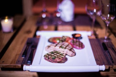 Bir tabak ızgara tavuk göğsü. Izgara patates, domates ve soğan.