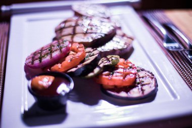 Bir tabak ızgara tavuk göğsü. Izgara patates, domates ve soğan.