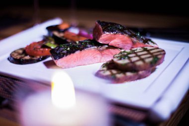 Izgara patates ve domatesli ızgara somon filetosu.