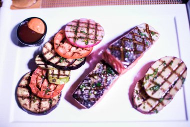 Izgara patates ve domatesli ızgara somon filetosu.