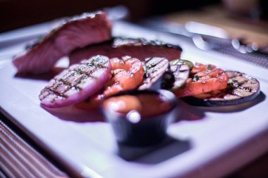 Izgara patates ve domatesli ızgara somon filetosu.