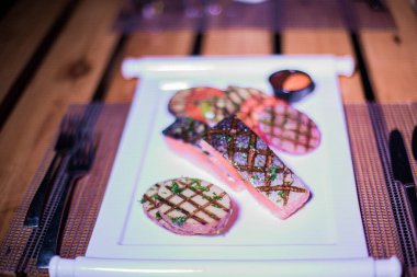 Izgara patates ve domatesli ızgara somon filetosu.