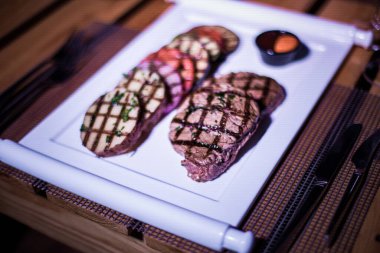 Kızarmış patates, domates ve soğanlı bir tabak et.